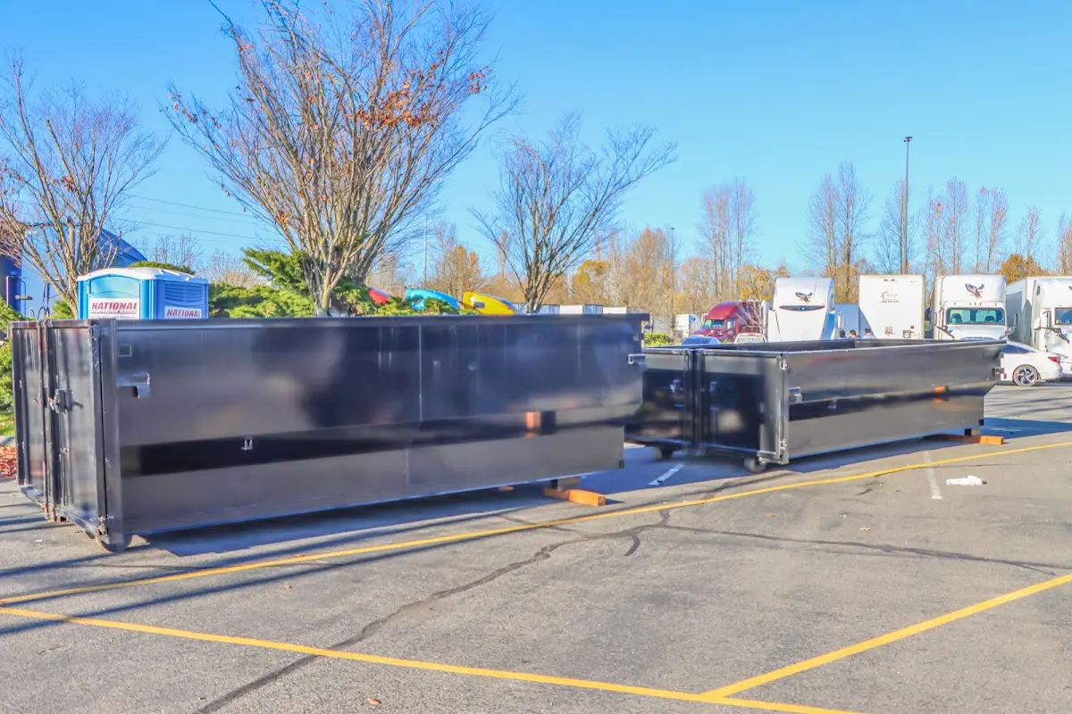 Professional dumpster rental service with roll-off container on residential driveway in Clyde